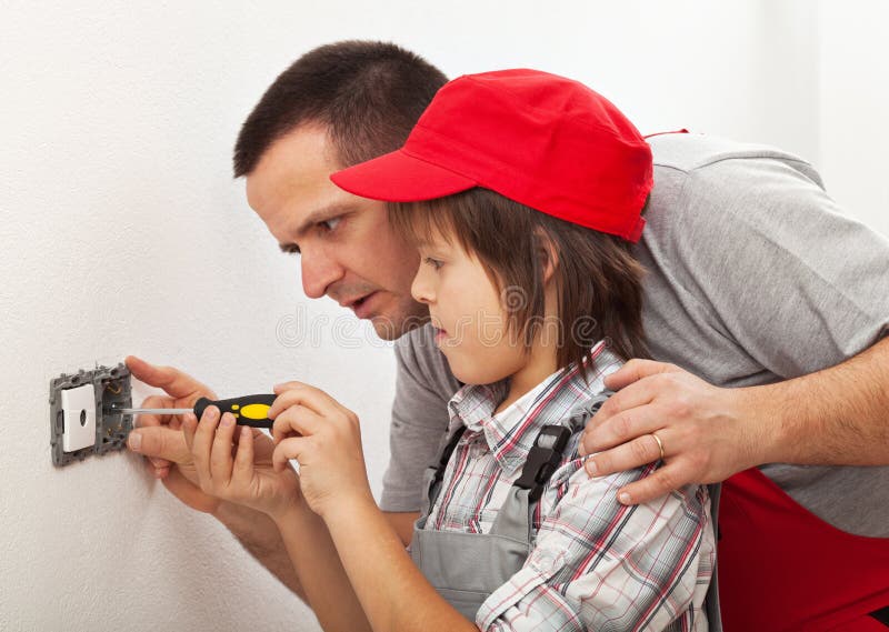 Father teaching son the basics of electrical work around the house. Father teaching son the basics of electrical work around the house