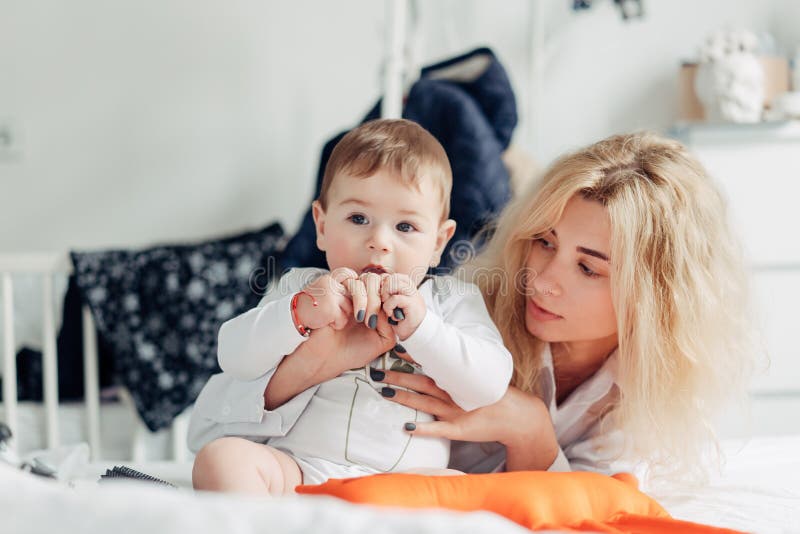 generi il gioco con il suo bambino nella camera da letto fotografia stock libera da diritti generi il gioco con il suo bambino nella camera da letto fotografia stock libera da diritti