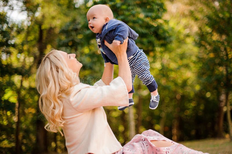 Generi il gioco con un figlio sveglio del bambino in un parco immagine stock libera da diritti Generi il gioco con un figlio sveglio del bambino in un parco immagine stock libera da diritti