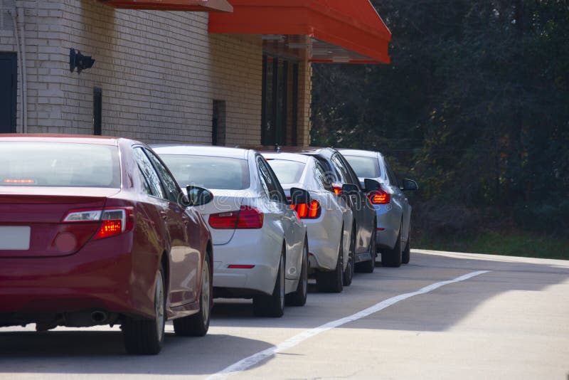 Generic drive thru pickup window with cars waiting in line to get their products or food