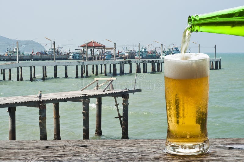 Geniet van een biertje aan de pier van het vissersdorp stock foto's