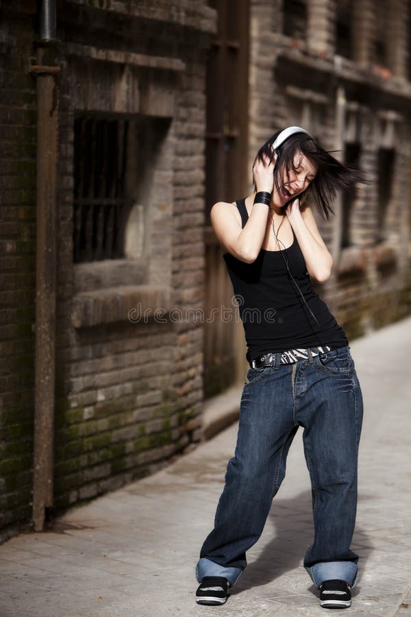 Beautiful young girl enjoying music in urban alley. Beautiful young girl enjoying music in urban alley