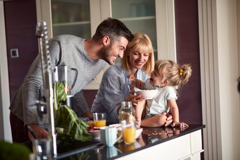 Genitori con la figlia divertendosi nella cucina immagini stock Genitori con la figlia divertendosi nella cucina immagini stock