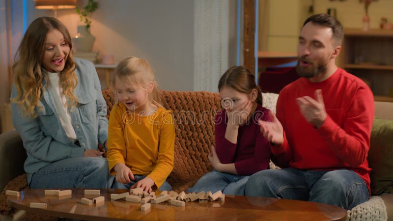 Genitori felici bambini bambine che giocano a botte di legno costruiscono spensierate figlie di papà stock footage