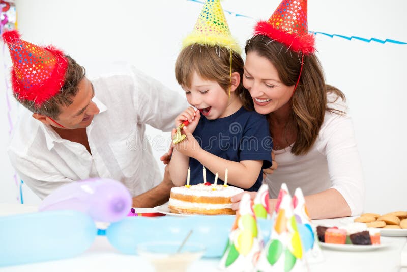 Genitori felici che celebrano compleanno del loro figlio immagini stock libere da diritti Genitori felici che celebrano compleanno del loro figlio immagini stock libere da diritti