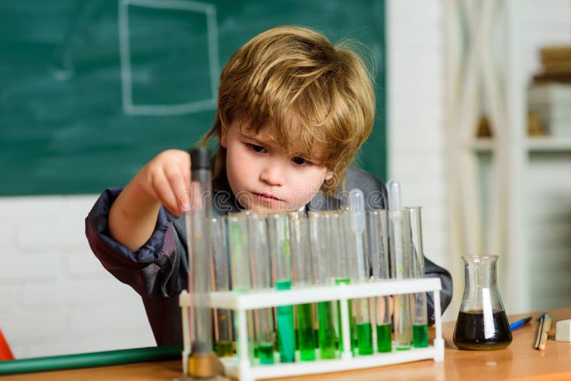Genius pupil Analisi chimica Concetto di scienza Sperimentare Wunderkind con chimica Tubi di prova con microscopio immagini stock libere da diritti Genius pupil Analisi chimica Concetto di scienza Sperimentare Wunderkind con chimica Tubi di prova con microscopio immagini stock libere da diritti
