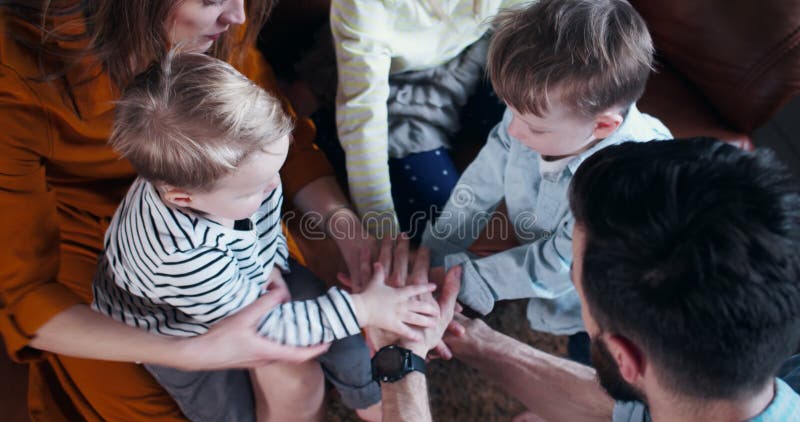 Genom att stänga av en ung, helig kaukasisk familj med tre barn som förenar sig med händer och njuter av tid tillsammans med långs