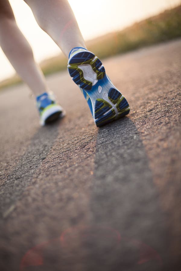 genomkörare för kvinna för wellness för soluppgång för running sko för löpare för väg för jog för kondition för closeupbegreppsfo