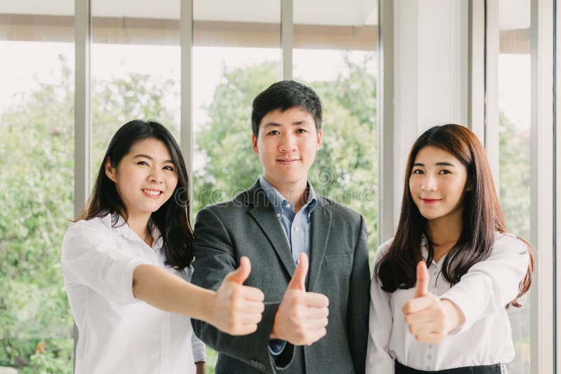 Gens d'affaires asiatiques réussis montrant le pouce photos libres de droits Gens d'affaires asiatiques réussis montrant le pouce photos libres de droits