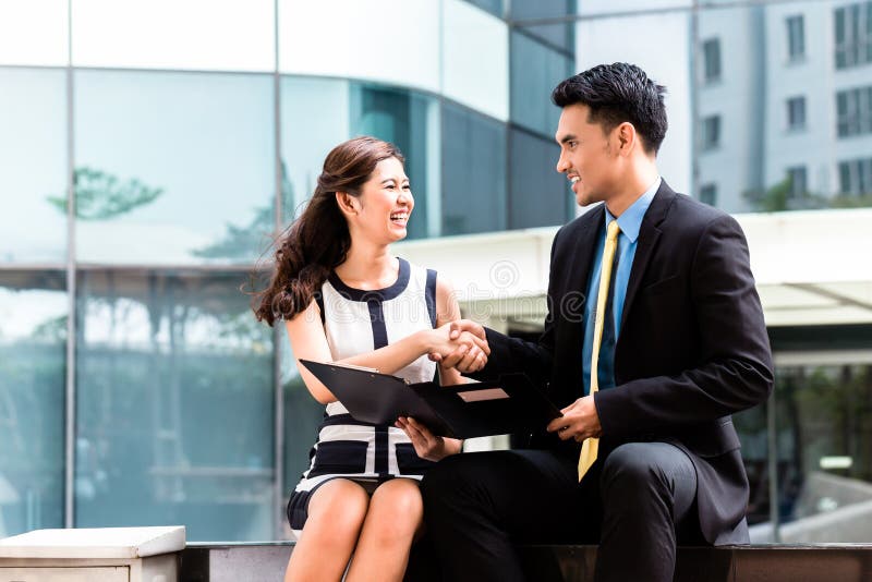 Gens d'affaires asiatiques travaillant dehors sur des documents photographie stock Gens d'affaires asiatiques travaillant dehors sur des documents photographie stock