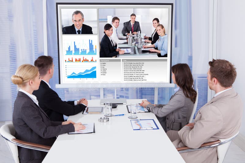 Gens d'affaires dans la vidéoconférence à la table image stock Gens d'affaires dans la vidéoconférence à la table image stock