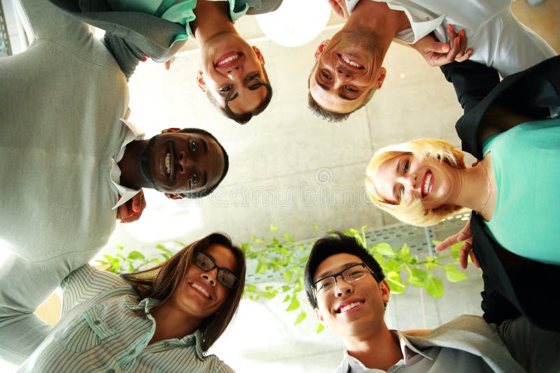 Smiling business people with their heads together representing concept of ftiendship and teamwork. Smiling business people with their heads together representing concept of ftiendship and teamwork