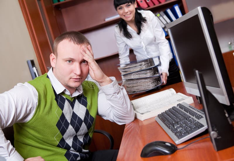 Young man in casual clothes and his colleague loaded with folders. Young man in casual clothes and his colleague loaded with folders