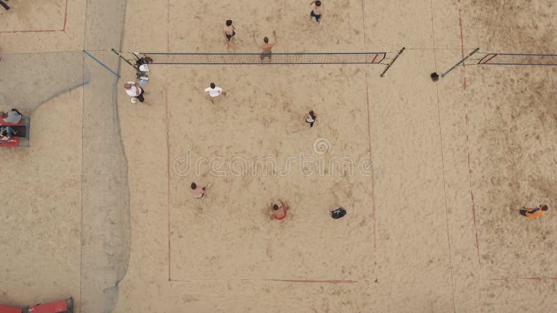Gente aerea del colpo che gioca il volleyall della spiaggia su due settori coperti di sabbia