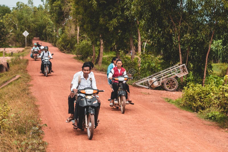 Gente cambogiana che conduce i motorini attraverso la Cambogia rurale fotografia stock libera da diritti Gente cambogiana che conduce i motorini attraverso la Cambogia rurale fotografia stock libera da diritti