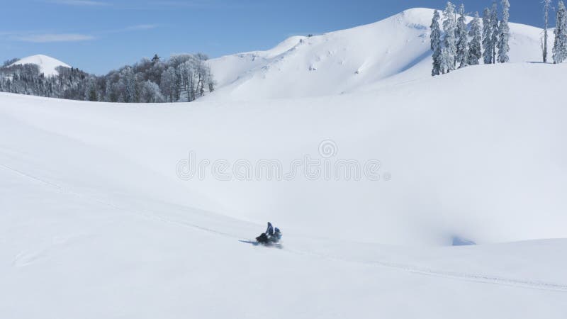 Gente che cavalca la motoslitta con snowboard in altipiani nevosi giorno d'inverno soleggiato