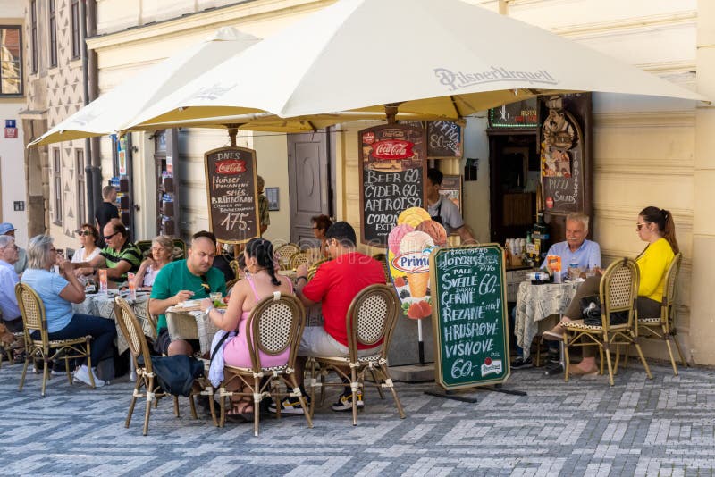 Prague, Czech Republic - 4 September 2022: People eating on the terrace of a restaurant. Prague, Czech Republic - 4 September 2022: People eating on the terrace of a restaurant