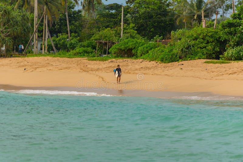 Gente che naviga sulla spiaggia in sabbia dorata a Midigama, Sri Lanka fotografia stock Gente che naviga sulla spiaggia in sabbia dorata a Midigama, Sri Lanka fotografia stock