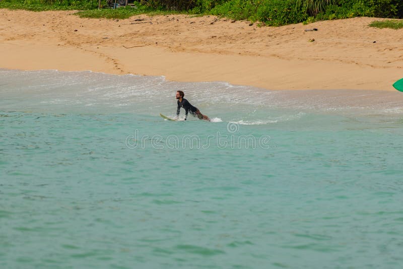 Gente che naviga sulla spiaggia in sabbia dorata a Midigama, Sri Lanka fotografia stock libera da diritti Gente che naviga sulla spiaggia in sabbia dorata a Midigama, Sri Lanka fotografia stock libera da diritti