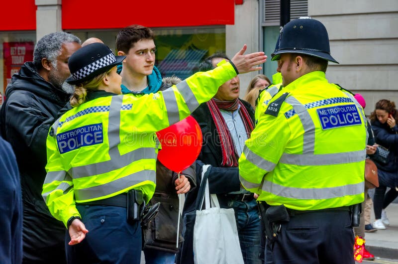 Gente de ayuda de señora Police en Londres, Reino Unido fotografía de archivo libre de regalías Gente de ayuda de señora Police en Londres, Reino Unido fotografía de archivo libre de regalías