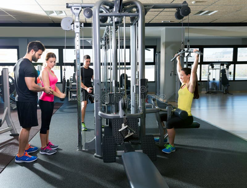 Gente de la aptitud del entrenamiento del gimnasio del sistema de la polea del cable imagen de archivo libre de regalías Gente de la aptitud del entrenamiento del gimnasio del sistema de la polea del cable imagen de archivo libre de regalías