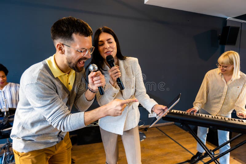 Gente de negocios haciendo ejercicio de entrenamiento de equipo durante el seminario de formación de equipos cantando karaoke fotografía de archivo