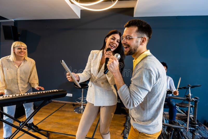 Gente de negocios haciendo ejercicio de entrenamiento de equipo durante el seminario de formación de equipos cantando karaoke imágenes de archivo libres de regalías