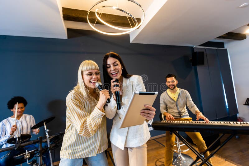 Gente de negocios haciendo ejercicio de entrenamiento de equipo durante el seminario de formación de equipos cantando karaoke imagen de archivo libre de regalías
