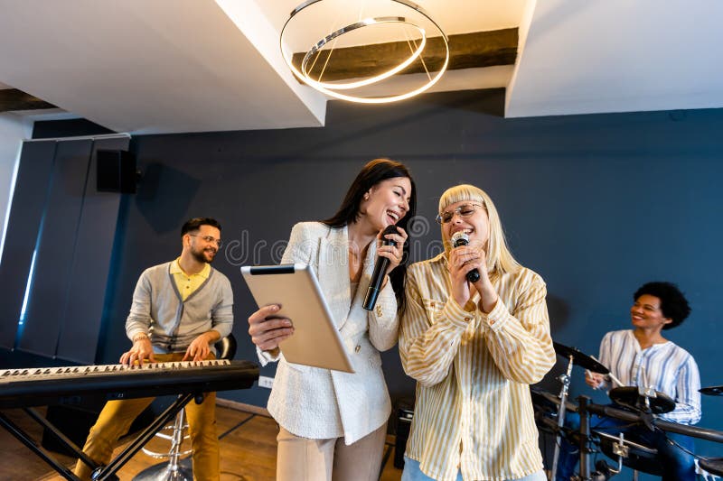 Gente de negocios haciendo ejercicio de entrenamiento de equipo durante el seminario de formación de equipos cantando karaoke fotografía de archivo libre de regalías