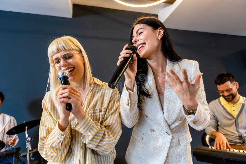 Gente de negocios haciendo ejercicio de entrenamiento de equipo durante el seminario de formación de equipos cantando karaoke imagen de archivo libre de regalías
