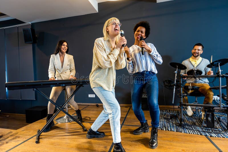Gente de negocios haciendo ejercicio de entrenamiento de equipo durante el seminario de formación de equipos cantando karaoke imagenes de archivo