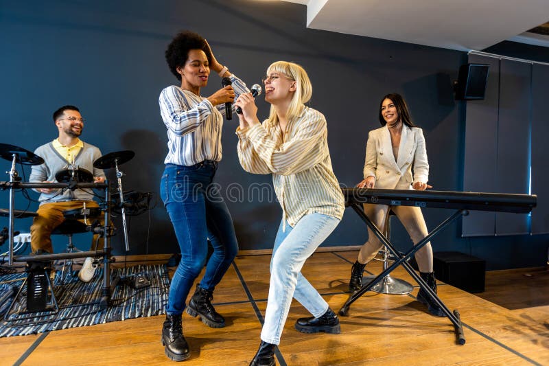 Gente de negocios haciendo ejercicio de entrenamiento de equipo durante el seminario de formación de equipos cantando karaoke fotografía de archivo