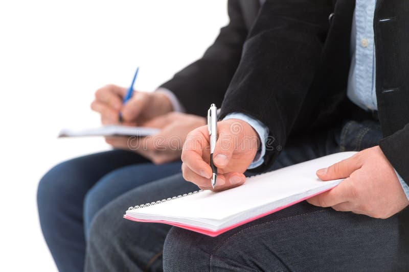 Gente di affari che si siede nella fila e nella scrittura fotografie stock libere da diritti Gente di affari che si siede nella fila e nella scrittura fotografie stock libere da diritti