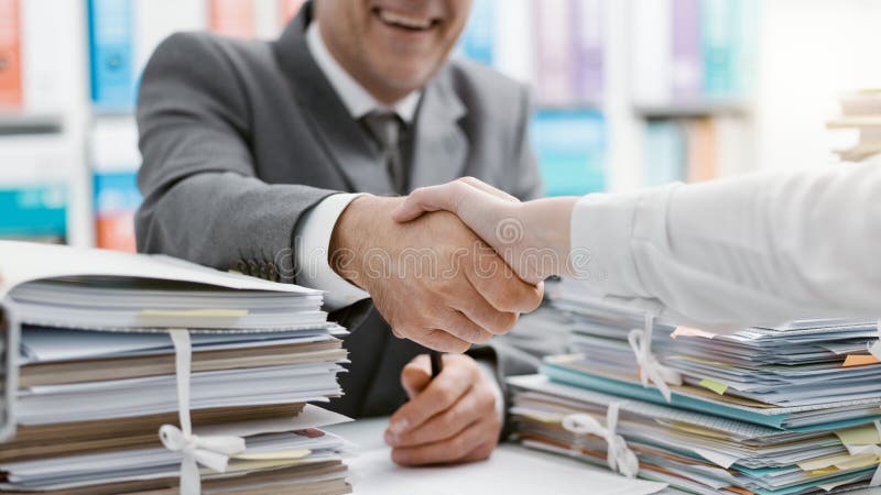 Gente di affari che stringe le mani nell'ufficio immagine stock libera da diritti Gente di affari che stringe le mani nell'ufficio immagine stock libera da diritti