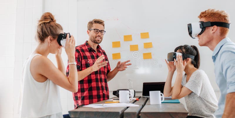 Gente di affari che usando gli occhiali di protezione di realtà virtuale nel corso della riunione immagine stock libera da diritti Gente di affari che usando gli occhiali di protezione di realtà virtuale nel corso della riunione immagine stock libera da diritti