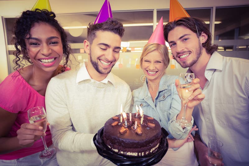 Gente di affari con la torta di compleanno che gode del partito fotografia stock Gente di affari con la torta di compleanno che gode del partito fotografia stock