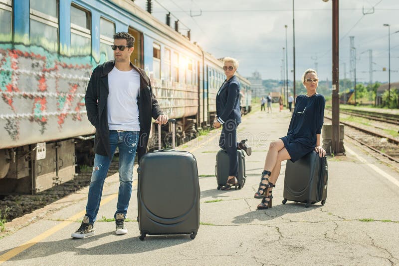 Gente di affari con la valigia che posa sulla stazione ferroviaria immagine stock libera da diritti Gente di affari con la valigia che posa sulla stazione ferroviaria immagine stock libera da diritti