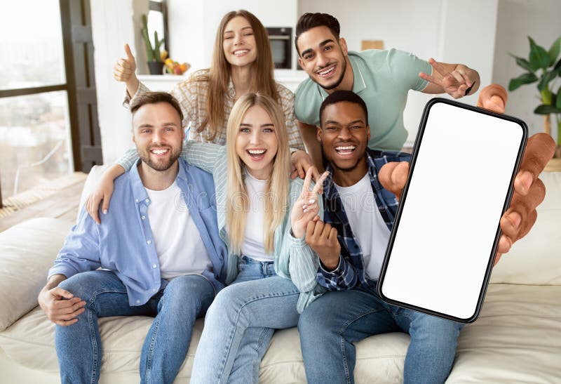 Gente diversa que muestra la pantalla blanca vacía de un smartphone y que hace gestos sí foto de archivo