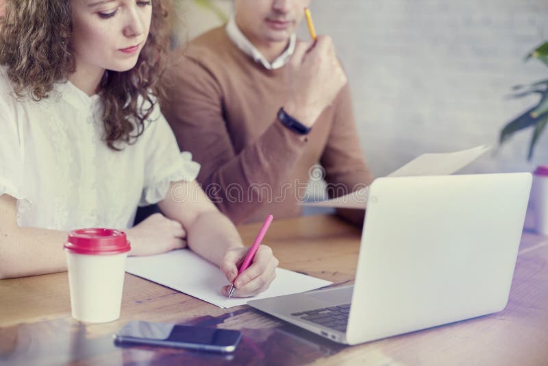 Gente joven de los socios comerciales que trabaja junto, discutiendo idea creativa en oficina Usando el ordenador portátil modern fotografía de archivo libre de regalías Gente joven de los socios comerciales que trabaja junto, discutiendo idea creativa en oficina Usando el ordenador portátil modern fotografía de archivo libre de regalías