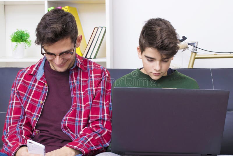 Gente joven en casa con el ordenador imagen de archivo Gente joven en casa con el ordenador imagen de archivo