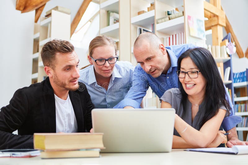 Gente joven en el ordenador portátil como equipo de lanzamiento imágenes de archivo libres de regalías Gente joven en el ordenador portátil como equipo de lanzamiento imágenes de archivo libres de regalías