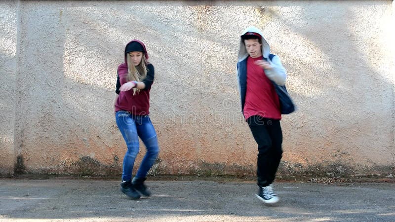 Gente joven que baila en el estilo del breakdance de la calle