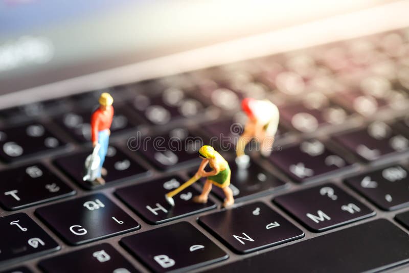 Gente miniatura: gruppo del lavoratore con il bottone su un keyboa del computer immagini stock Gente miniatura: gruppo del lavoratore con il bottone su un keyboa del computer immagini stock