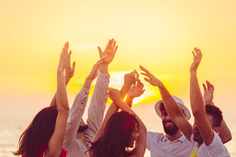 Gente que baila en la playa con las manos para arriba concepto sobre partido, música y gente imagen de archivo libre de regalías Gente que baila en la playa con las manos para arriba concepto sobre partido, música y gente imagen de archivo libre de regalías