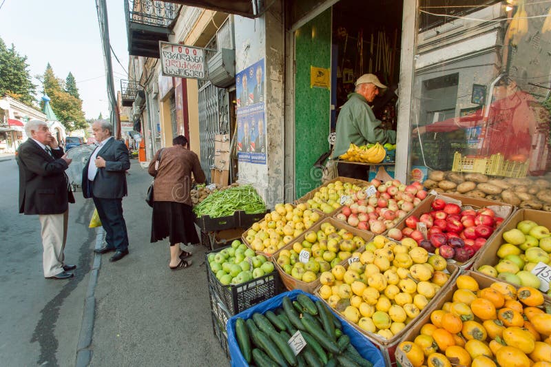 Gente que compra frutas y verduras frescas en tienda al por menor de la ciudad vieja fotografía de archivo Gente que compra frutas y verduras frescas en tienda al por menor de la ciudad vieja fotografía de archivo