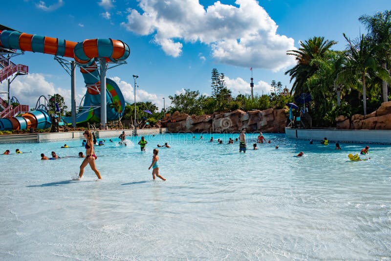 Gente que disfruta de la piscina de la onda y de la vista parcial del rizo de Karekare en fondo nublado del cielo azul claro en A imagen de archivo Gente que disfruta de la piscina de la onda y de la vista parcial del rizo de Karekare en fondo nublado del cielo azul claro en A imagen de archivo
