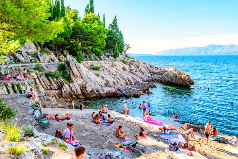 Gente que nada y que toma el sol en las rocas en Croacia meridional fotos de archivo libres de regalías Gente que nada y que toma el sol en las rocas en Croacia meridional fotos de archivo libres de regalías