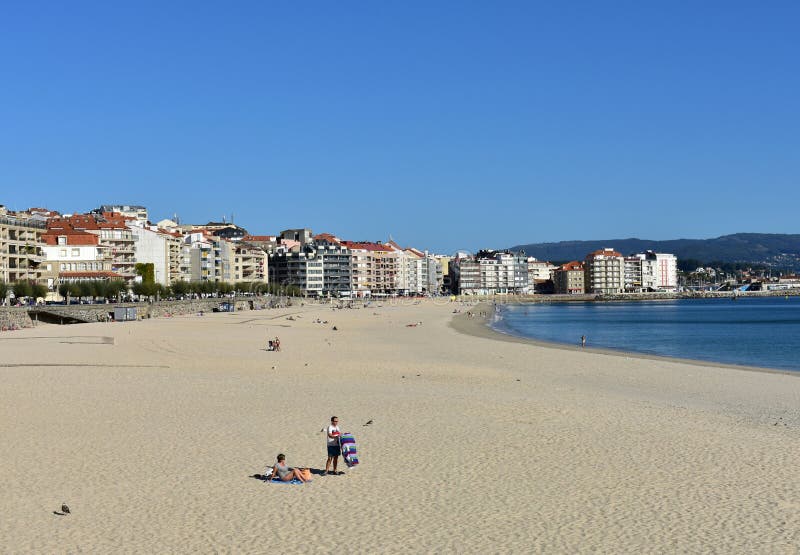 Gente que toma el sol en la playa Arena brillante y mar azul Día soleado, cielo claro Sanxenxo, Galicia, España 7 de octubre de 2 fotos de archivo libres de regalías Gente que toma el sol en la playa Arena brillante y mar azul Día soleado, cielo claro Sanxenxo, Galicia, España 7 de octubre de 2 fotos de archivo libres de regalías