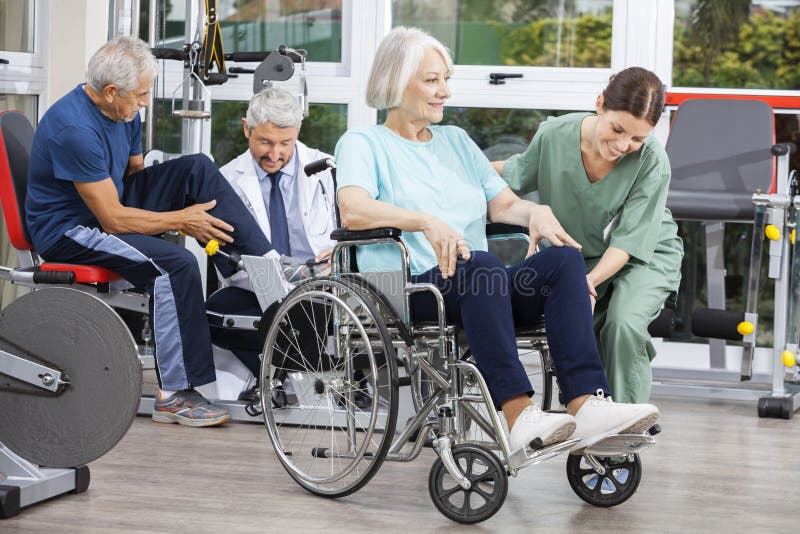 Gente senior che è assistita dai fisioterapisti nel centro di riabilitazione fotografia stock Gente senior che è assistita dai fisioterapisti nel centro di riabilitazione fotografia stock