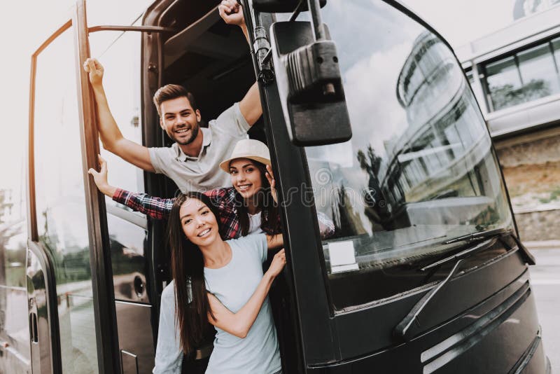 Gente sonriente joven que viaja en el autobús turístico foto de archivo libre de regalías Gente sonriente joven que viaja en el autobús turístico foto de archivo libre de regalías